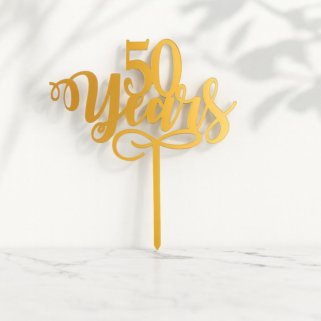 Gold '50 Years' cake topper on a white background