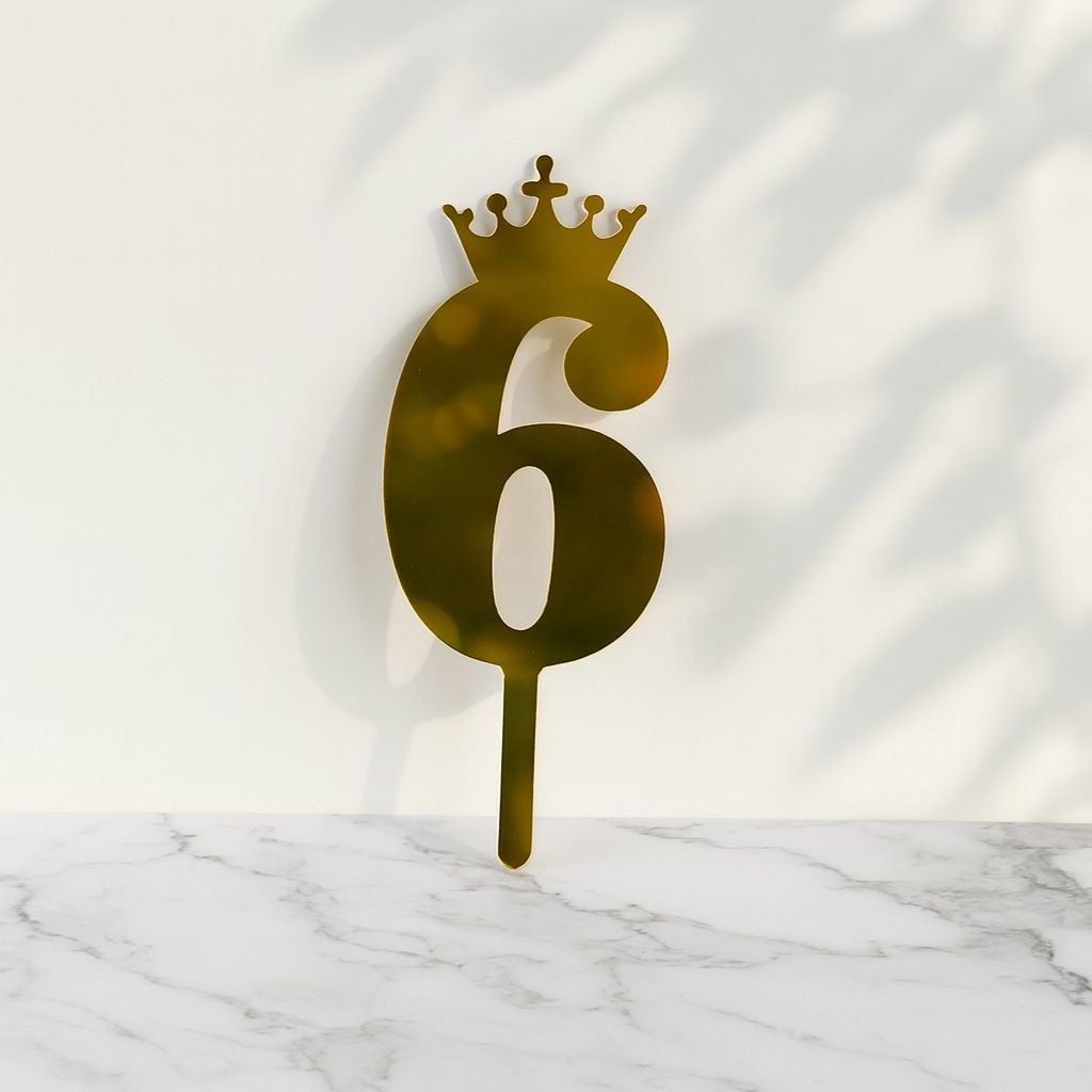 Gold number '6' with a crown on a marble surface