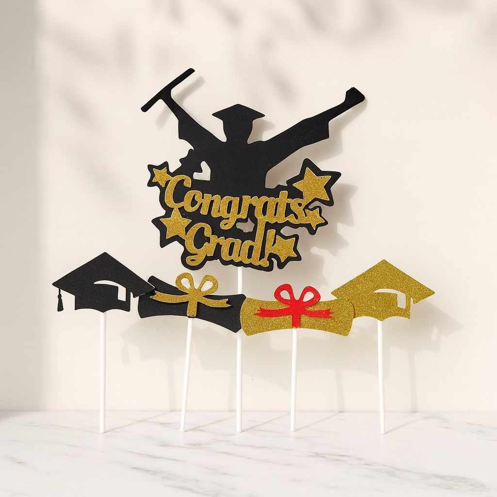 Graduation-themed cake topper with 'Congrats Grad' text on a white background